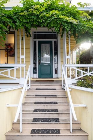Charming Yellow House with Green Door and White Railings
