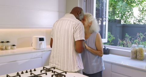 Senior couple embracing in bright modern kitchen interior