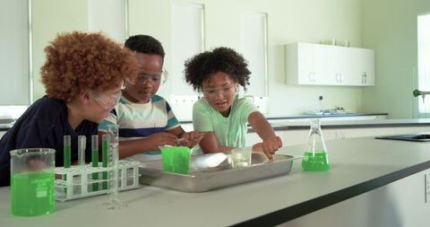 African american students conducting colorful chemistry experiment together in science lab