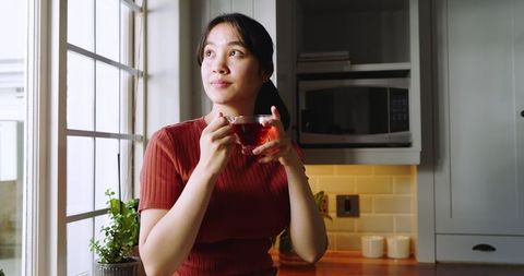 Woman Enjoying Tea in Calming Kitchen Ambiance