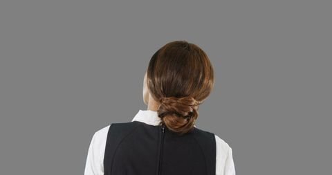 Businesswoman interacting with virtual screen on grey background.