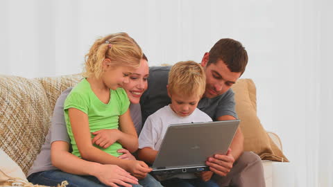 Happy Family Bonding Time with Laptop on Couch
