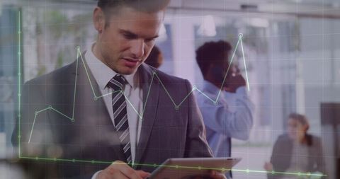 Businessman tapping tablet with data dashboard overlay in modern office workspace