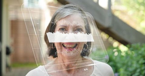 Senior woman smiling with augmented reality data overlay in sunny backyard portrait