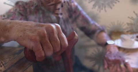 Elderly Hand Gripping Cane with Pandemic Reflections