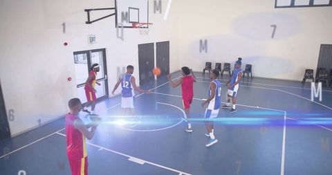 Young basketball players passing ball on indoor court showing teamwork and athletic play