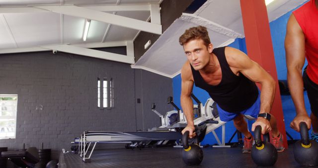 Focused Young Man Training with Kettlebells in Gym - Download Free Stock Images Pikwizard.com