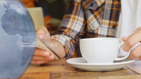 Man Engaging with Smartphone Beside Coffee and Futuristic Globe Animation