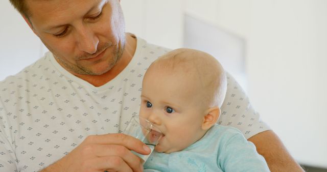 Father Offering Water to Baby at Home - Download Free Stock Images Pikwizard.com