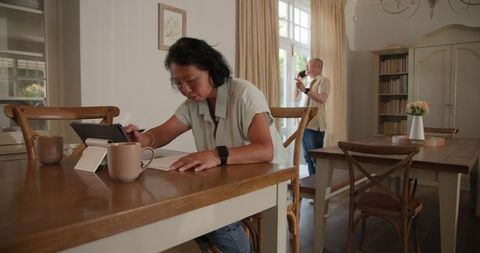 Couple integrating tablet technology in cozy dining area
