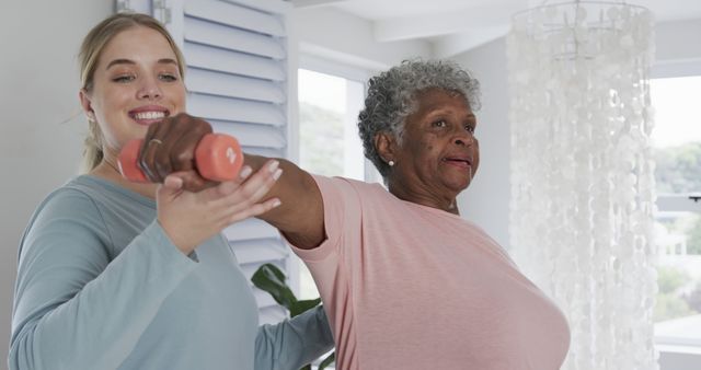 Young Physical Therapist Assisting Senior Woman with Arm Exercise at Home - Download Free Stock Images Pikwizard.com