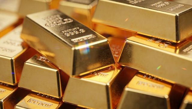Stacked shining gold bars with 999.9 purity marks and serial numbers for luxury investment