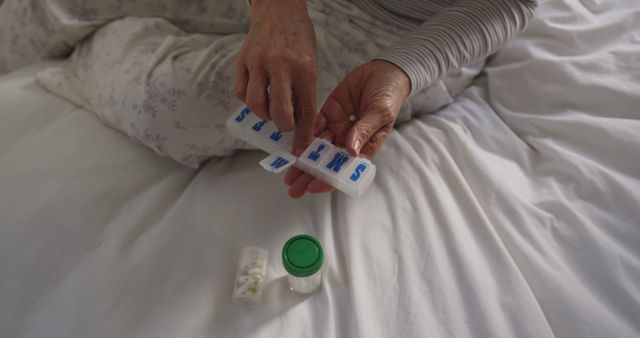 Senior sorting medication in weekly pill organizer - Download Free Stock Images Pikwizard.com