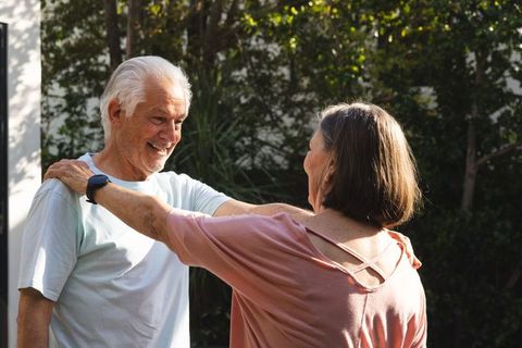 Senior Couple Dancing Enjoying Sunlit Garden