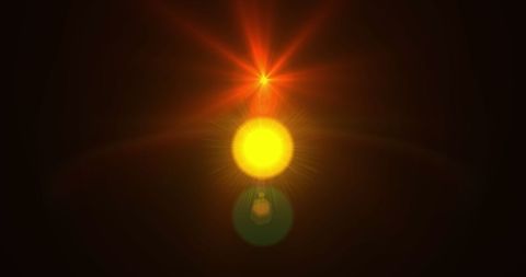Yellow light with radiant red star in motion on black background