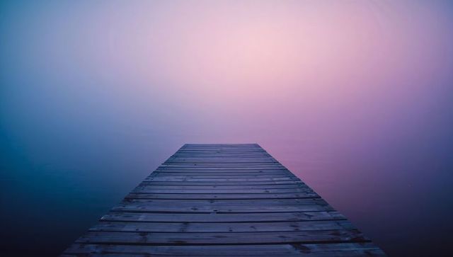 Serene wooden dock immersed in mystical lavender mist