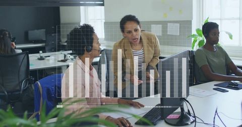 Supervisor leaning over guiding call center agent with headset and hud data chart overlay