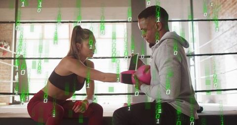 Female Boxer Training with Coach Holding Pink Focus Mitts in Ring with Binary Overlay