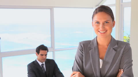 Confident Businesswoman with Colleague by Ocean View Window