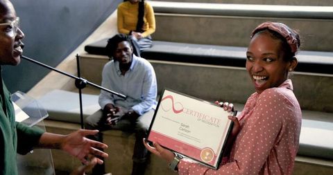 Women receiving award certificate at business seminar