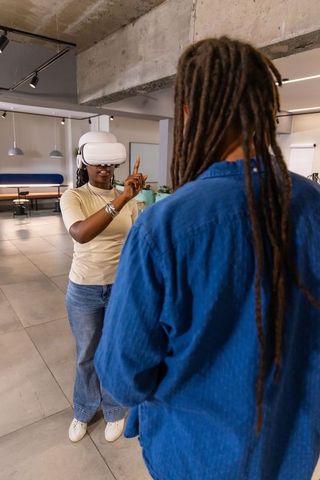 African american coworker testing vr headset while colleague observing in modern workspace