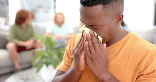 Young Man Sneezing Indoors, Blowing Nose with Tissue - Download Free Stock Images Pikwizard.com