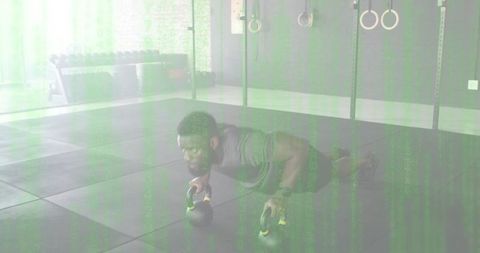 Kettlebell push-up strength training: man performing stabilizing core workout in gym