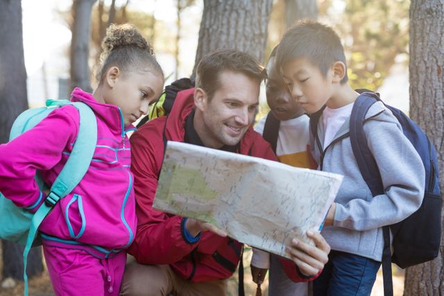 Teacher guiding a group of children while reading a map in a forest. Ideal for educational materials, outdoor adventure promotions, and teamwork concepts. Perfect for illustrating themes of learning, exploration, and nature activities.