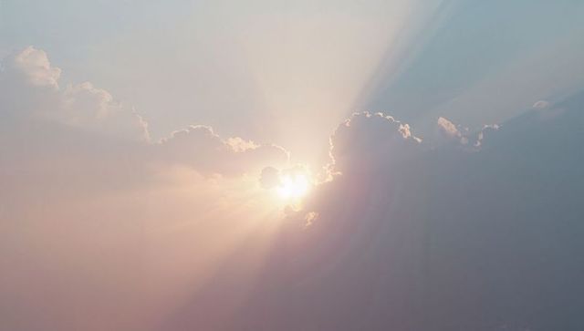 Radiant Sunrise Over Cloudscape with Silvery Rays