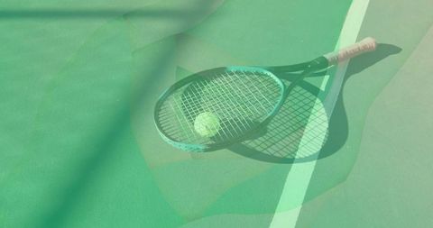 Tennis racket with ball on green hard court