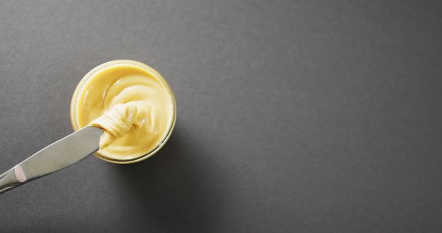 Close-Up of Peanut Butter in Container with Knife on Gray Background - Download Free Stock Images Pikwizard.com