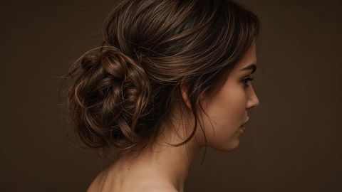 Elegant beautiful lady in profile posing with stylish low bun hairstyle