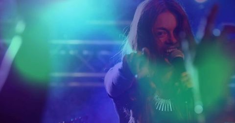 Energetic Singer Performing on Stage with Colorful Lighting