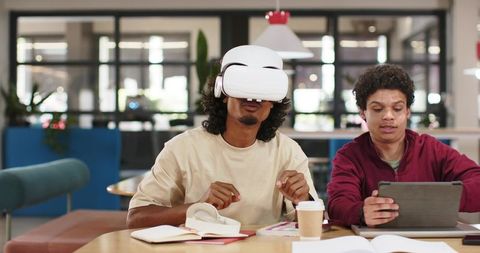 African American Students Using VR Headset and Tablet in Modern Co-working Study Lounge