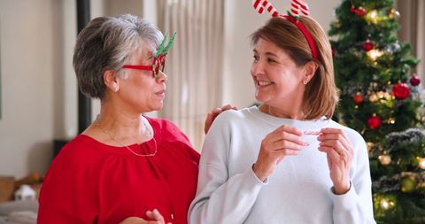 Mother and Daughter Celebrating Christmas by Festive Tree
