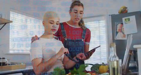 Two Women Collaborate with Tablet for Online Cooking Tutorial