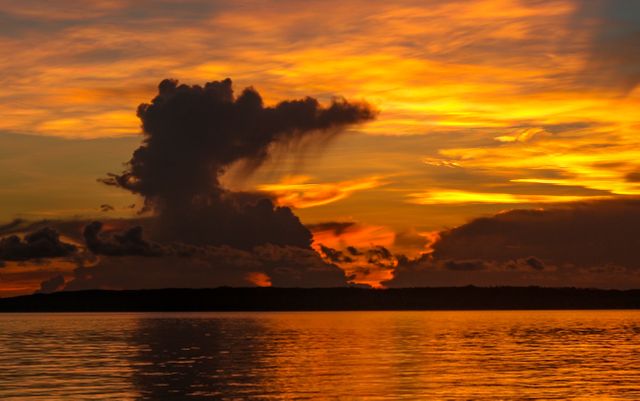 Dramatic Sunset Over Tranquil Lake with Silhouetted Cloud - Download Free Stock Photos Pikwizard.com