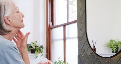 Senior woman skincare routine in minimalist bathroom