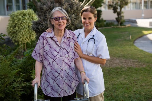 Female doctor assisting elderly woman using walker in backyard. Ideal for healthcare, senior care, and medical support themes. Useful for articles, brochures, and advertisements related to elderly care, rehabilitation, and nursing services.