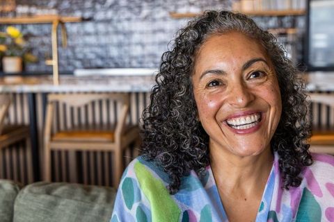 Smiling african american woman enjoying cafe lounge wearing colorful shawl headshot