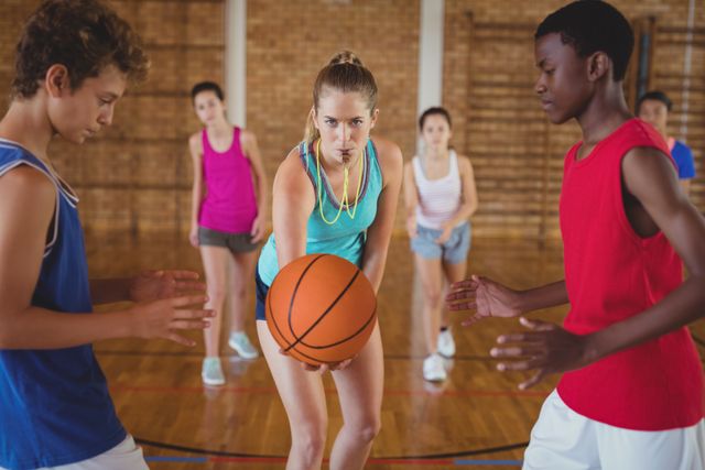 High school students are preparing to start a basketball game in a gym. This image can be used for educational materials, sports training guides, youth fitness programs, and promotional content for school sports events.