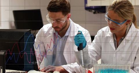 Laboratory Researchers Pipetting and Analyzing Data with Computer Charts and Test Tubes