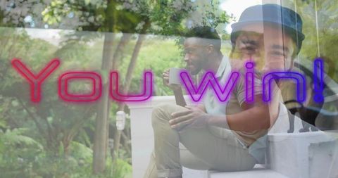 Two men sitting on porch steps holding mug with neon you win overlay double exposure