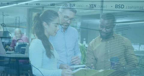 Collaborative team reviewing financial reports in modern open office with currency tickers
