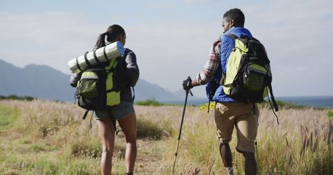Couple Hiking Countryside with Backpacks and Nordic Walking Poles - Download Free Stock Images Pikwizard.com