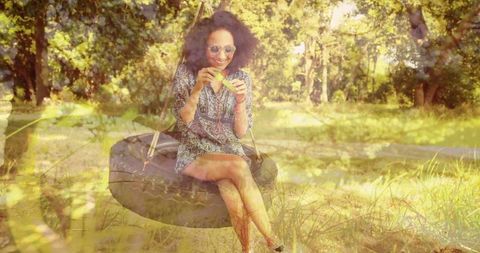 Relaxed Woman Sits on Tire Swing Eating Watermelon Outdoors - Download Free Stock Images Pikwizard.com