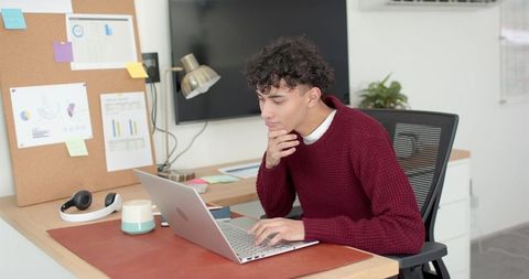Professional Man Focusing on Work at Modern Office Desk with Laptop