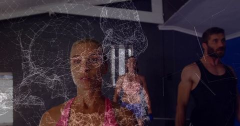 Female athlete standing focused in gym with digital network overlay for fitness tech