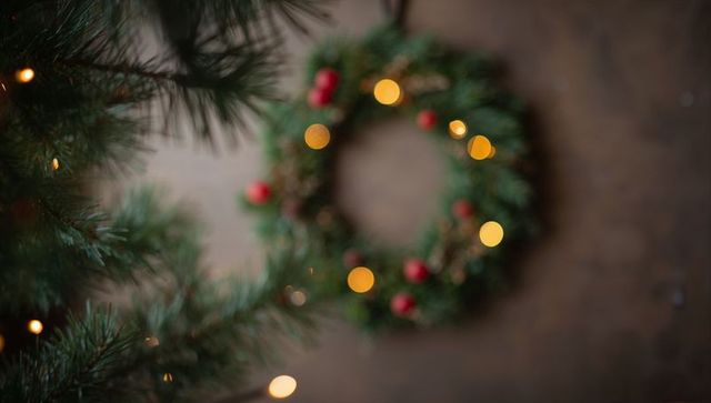 Cozy rustic Christmas wreath glowing with bokeh lights among evergreen branches