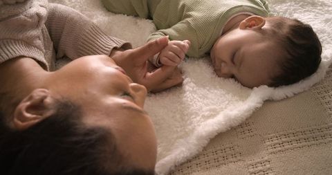 Mother and baby bonding on soft blanket